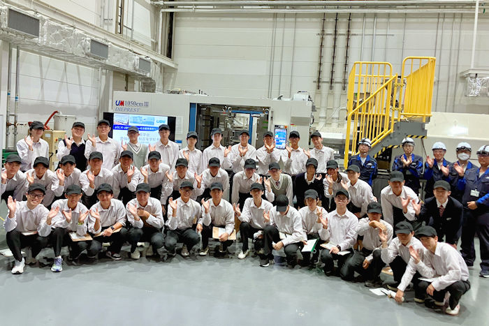 射出成形機の前で集合写真