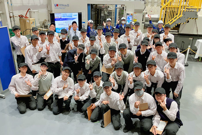 射出成形機の前で集合写真